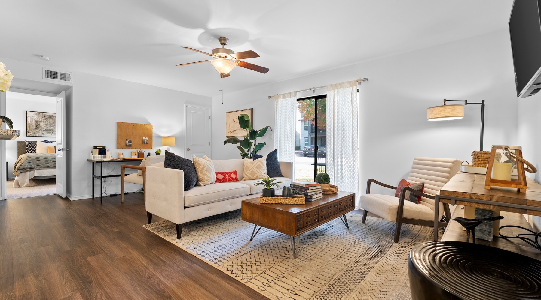 living room with seating table ceiling fan and wood floors