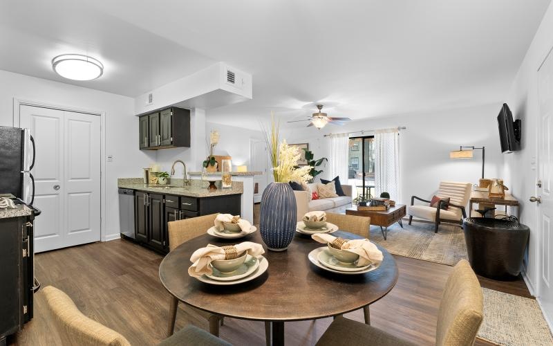 a living room and a table and chairs by a kitchen